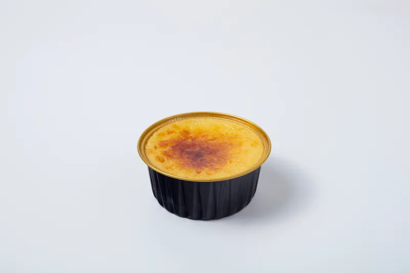 Classic Crème Brûlée — Authentic French custard infused with Madagascar vanilla bean, finished with a caramelized sugar crust cracked to order