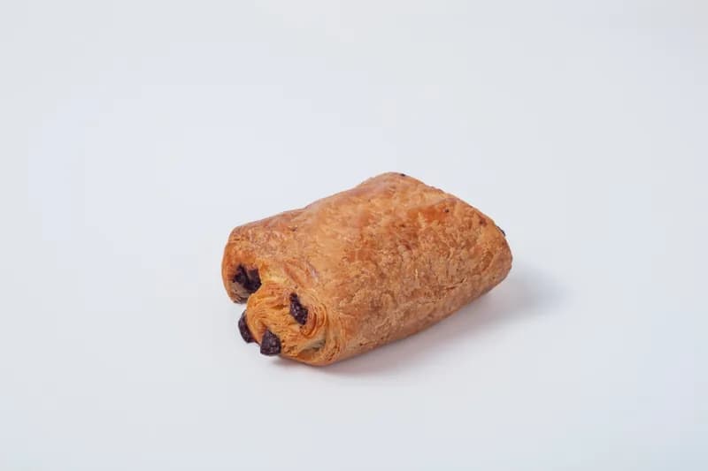 Pain au Chocolat — Traditional French chocolate croissant featuring flaky laminated dough wrapped around batons of premium dark chocolate
