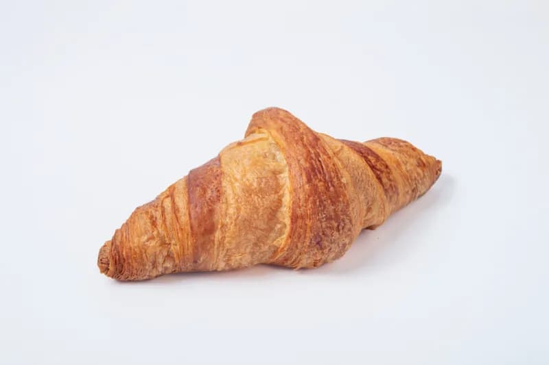 Croissant au Beurre — Classic French croissant with 48 hand-folded layers of premium French butter. Golden, flaky, and impossibly light