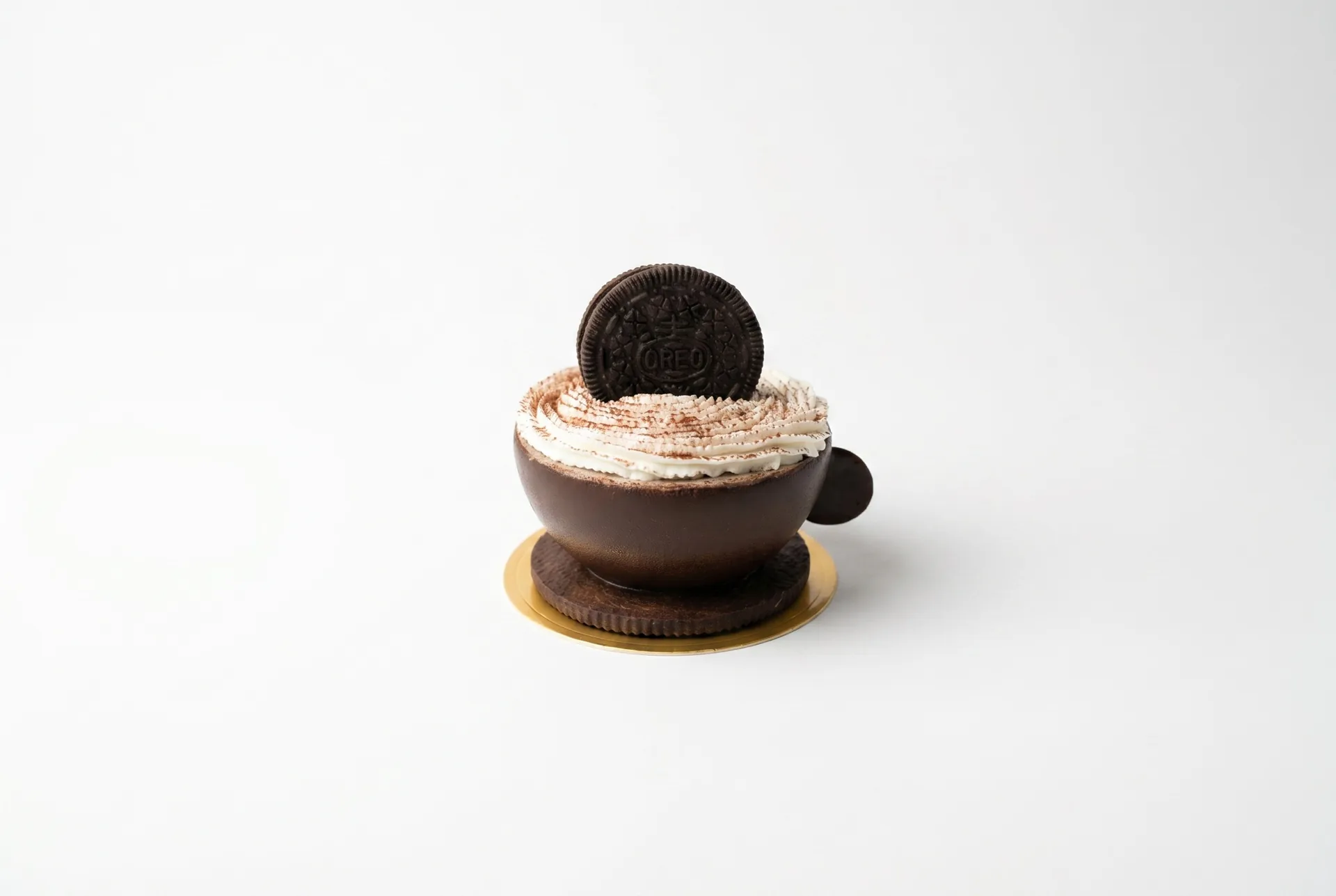 Oreo Cup — Glossy dark chocolate shell that cradles a luxurious vanilla cream infused with Oreo crumbles, crowned with a piped rosette and whole cookie. A sophisticated patisserie interpretation that marries crisp chocolate snap with textured filling.